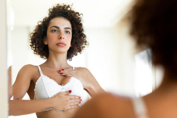 женщина проверяет свою грудь на рак - people cleavage color image clothing стоковые фото и изображения