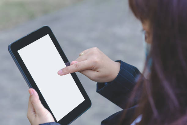 istock close up business woman hands using smartphone tablet typing and touch on white screen for working with app devices vintage style in park with sunrise and blur nature background. 1345818650