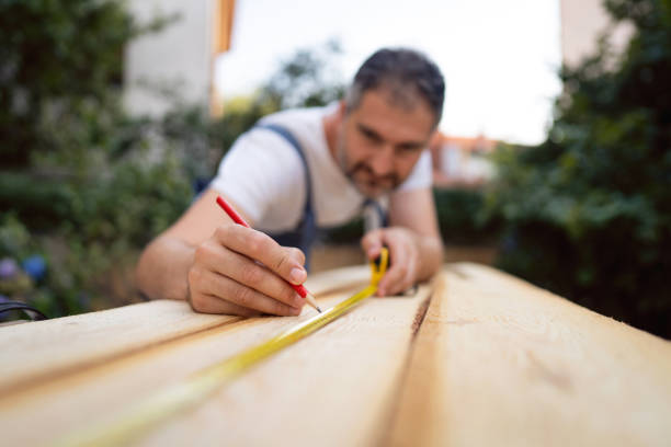 istock Carpenter marking with pencil the place where he gonna cut the timber after he using a tape measure for accurate determination 1345818749