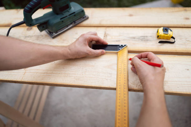 POV of an unrecognizable carpenter using the angular ruler to measure the timber stock photo