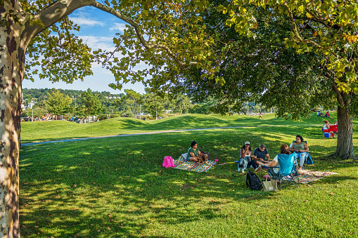 TARRYTOWN, NEW YORK - SEPTEMBER 18: People enjoy a picnic on the lawn on September 18 2021 in the Hudson River Walk Park in Tarrytown New York