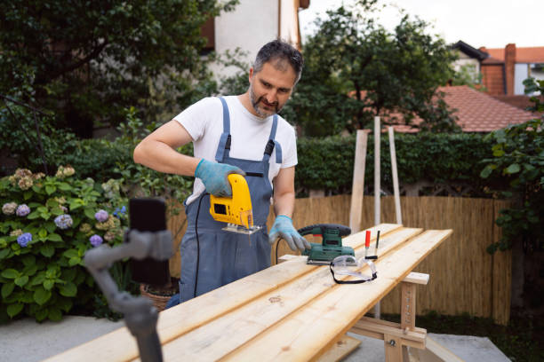 istock Skilled carpenter explaining the proper way for jigsaw use, while recording on mobile phone his DIY tutorial 1345819516