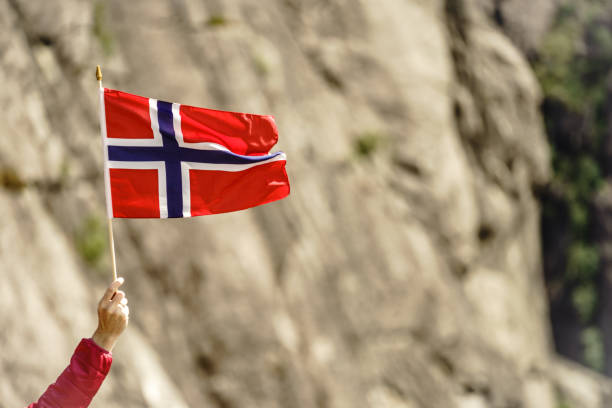 istock Tourist with norwegian flag in rocks mountains 1345819545