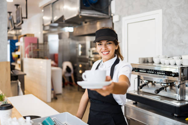 istock Beautiful young woman working on coffee maker machine 1345826240