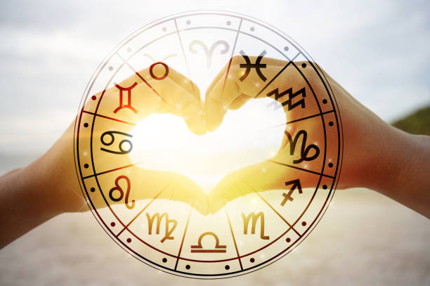 le mani delle donne e degli uomini sono la forma del cuore con la luce del sole che passa attraverso le mani hanno simboli astrologici - amorevole foto e immagini stock