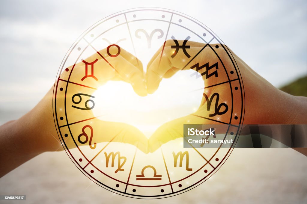 The hands of women and men are the heart shape with the sun light passing through the hands have astrological symbols Astrology Sign Stock Photo