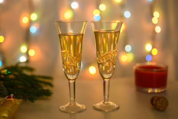 glasses against the background of a luminous garland are prepared for the new year. - martini cocktail christmas blue imagens e fotografias de stock