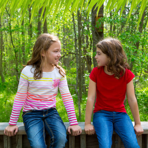 children friend girls talking on the jungle park forest stock photo