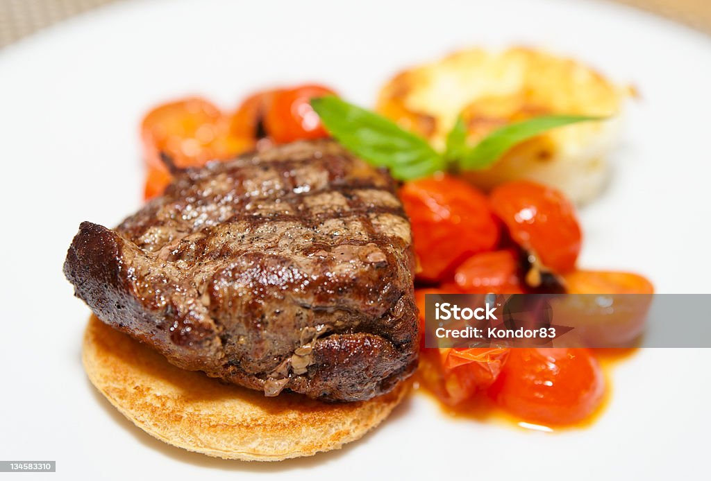 Tasty steak Tasty steak with fried cherry tomatos, cheese and basil Basil Stock Photo