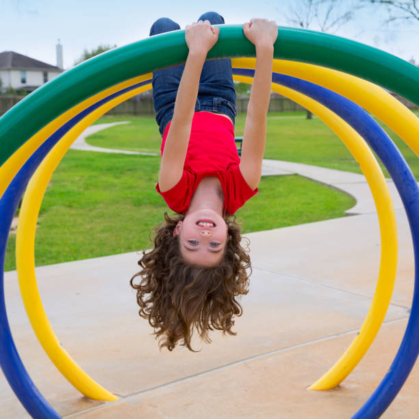 children kid girl upside down on a park ring children kid girl upside down on a park playground ring game sliding down stock pictures, royalty-free photos & images