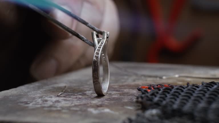 Handmade Jewelry making process. Jeweler crafting and cleaning the jewelery. Hardening of gold with fire. Grinding and polishing a gold ring.