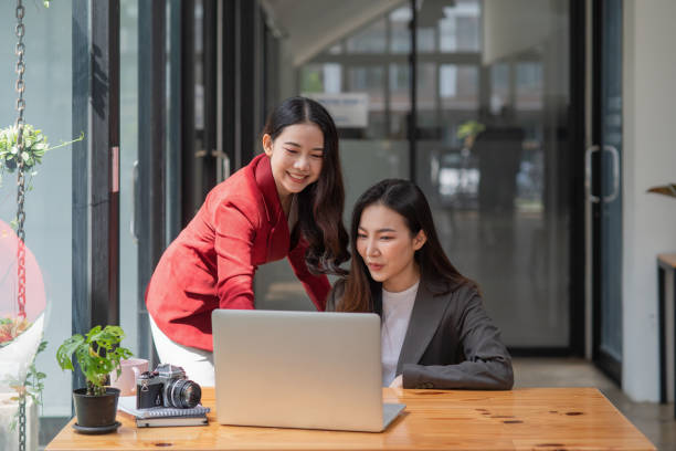 istock Two casual Asian businesswomen discussing work in the office 1345835549