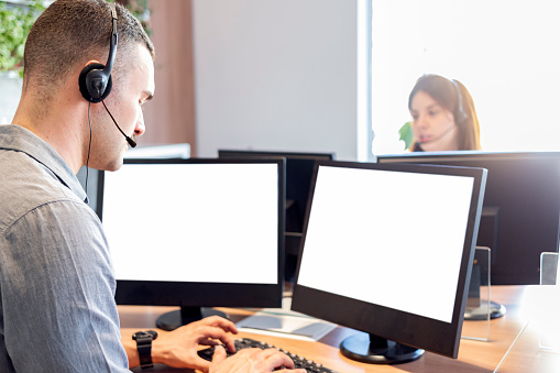 Photo of a man and a woman working in a call center.