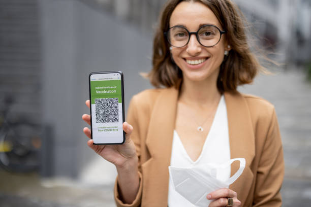 istock Woman show phone with Coronavirus Vaccination app 1345842060