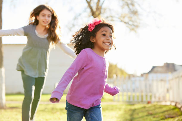 wieloetniczne dziewczyny bawiące się w bieganie w parku - child little girls smiling autumn zdjęcia i obrazy z banku zdjęć