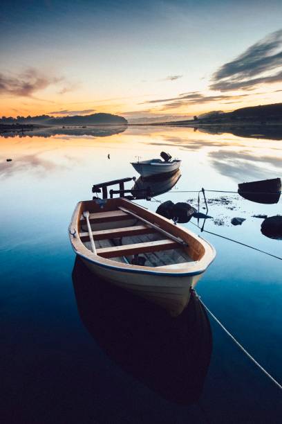 istock Rowing boats on calm waters in sunrise 1345846652
