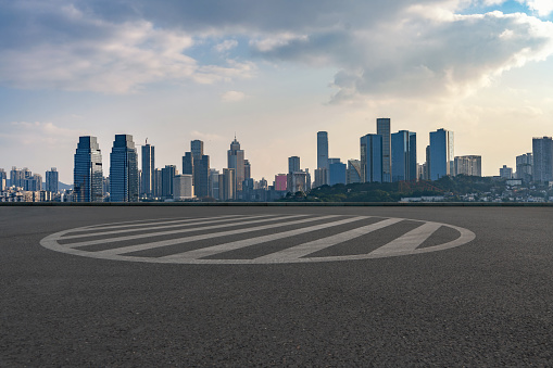 empty asphalt road in downtown of modern city with cityscape during sunrise.