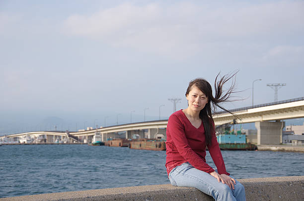 istock Asian woman sitting on seaside 134584674