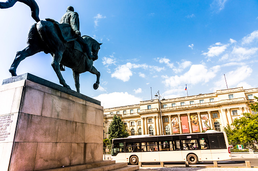 A bus leaving in front of the Equestrian Statue of Carol I and National Museum of Art in Bucharest city.