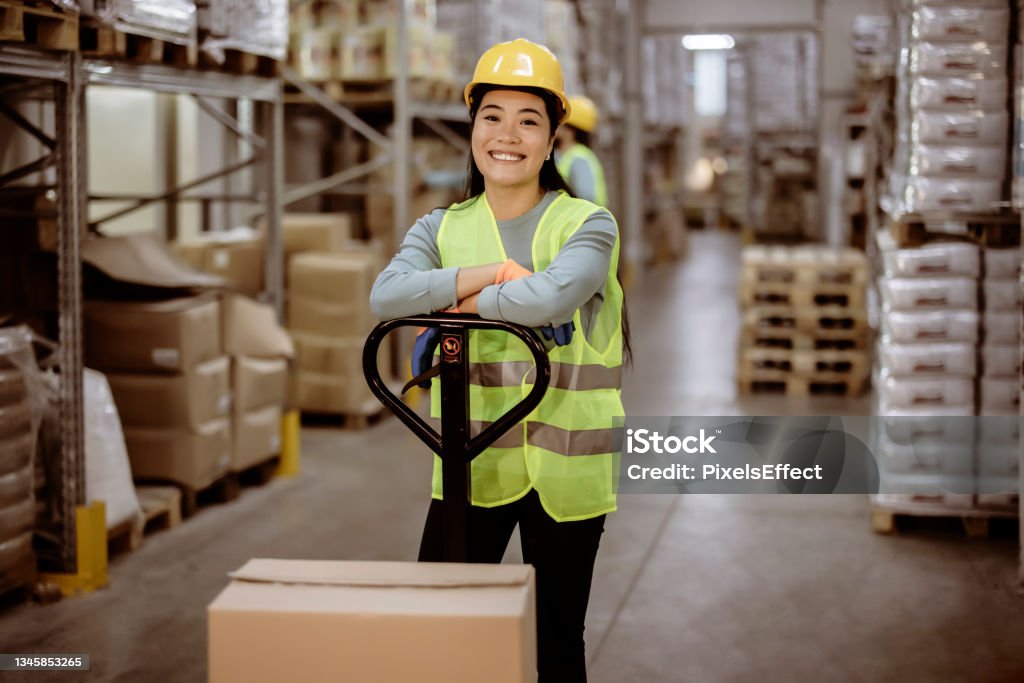 Logistical specialist Portrait of Beautiful Asian female staff smiling while looking at camera in a warehouse Warehouse Worker Stock Photo
