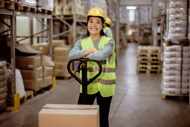 Logistical specialist Portrait of Beautiful Asian female staff smiling while looking at camera in a warehouse logistical stock pictures, royalty-free photos & images