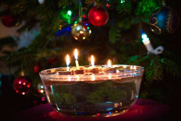 istock burning candles  on water surface, christmas atmosphere with tree background 1345853489