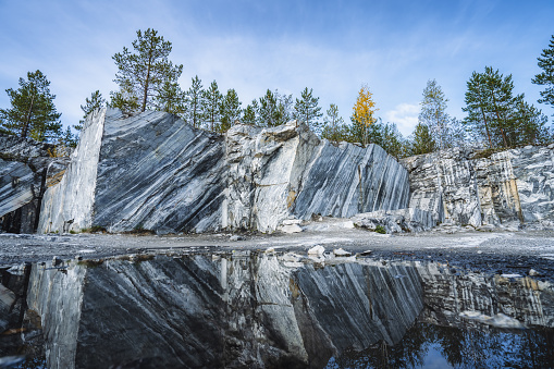 Italian quarry with smooth sections of marble in the Ruskeala Mountain Park on a sunny summer day.