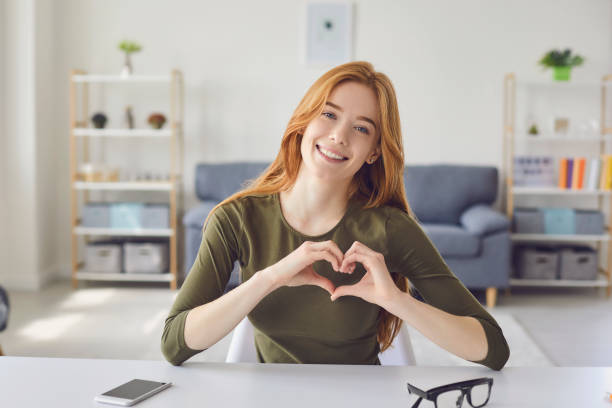 istock Delighted ginger woman gesturing heart in room. 1345854730