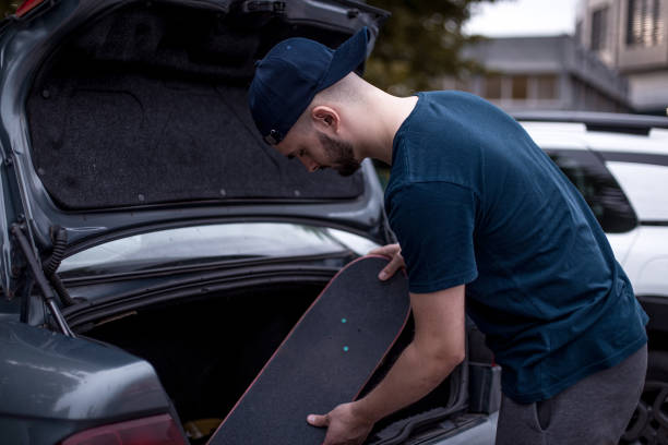 istock Young skateboarder packing / preparing his skate and gear 1345856328