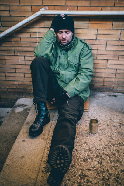 istock Poor homeless man sitting on subway station 1345859153