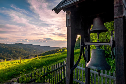Fentberg chapel with bells and mountain view at sunset