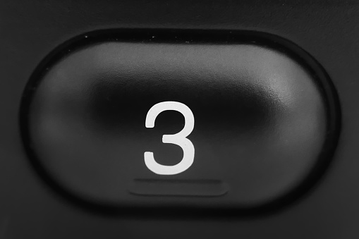 Number three in white on black plastic support