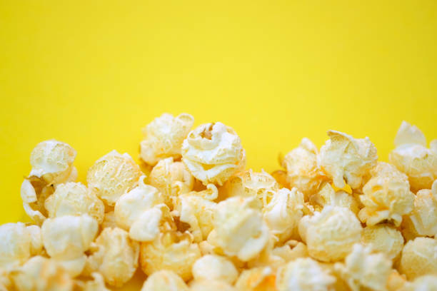 istock Salted popcorn with cheese flavor on a yellow background top view. 1345861085