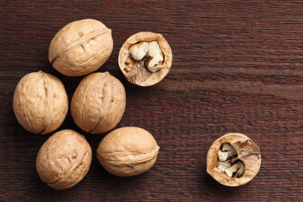 istock Top view of walnuts on wooden background 1345862554