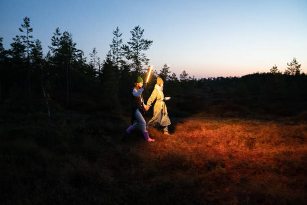istock Two women get lost in countryside after sunset walk hold hands and highlight pathway with led lamp 1345863846