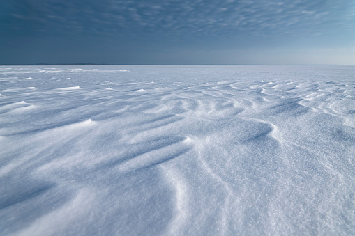 Snowy horizon. Large lake snow covered. White winter snowflakes background
