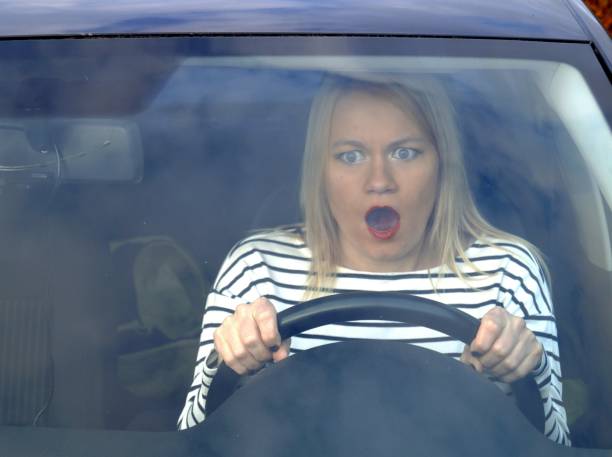 istock A frightened woman driving a car. 1345865024
