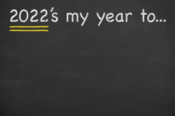 istock Human hand drawing 2022's my year to on blackboard background 1345866199