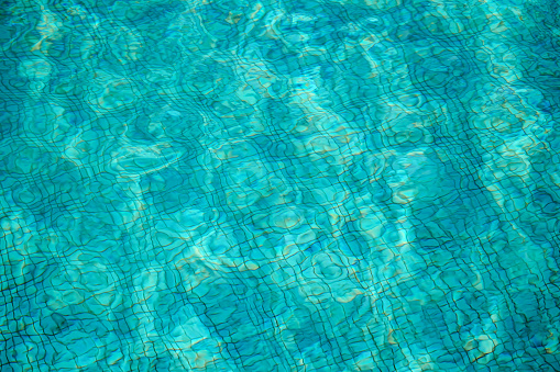 Swimming pool with stairs in blue water on a sunny summer day.