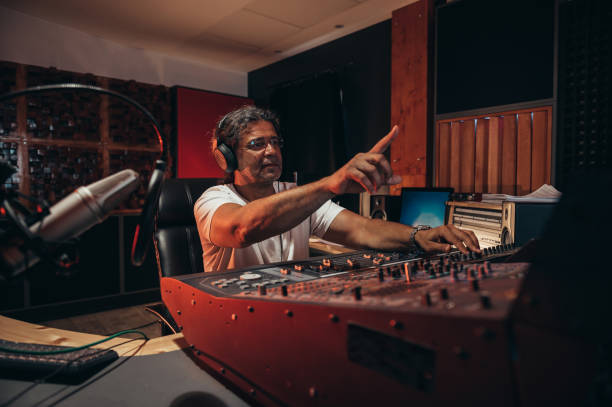istock Senior hispanic music producer working on a mixing soundboard while in his studio 1345867716