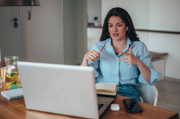 istock Beautiful young businesswoman using a laptop while working at home 1345867808