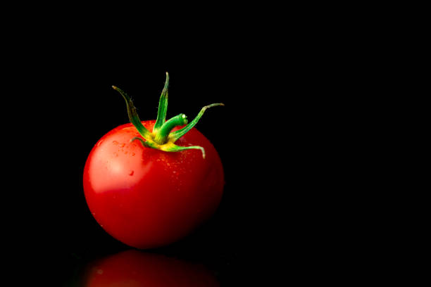 istock Washed cherry tomatoes on a black background, tomatoes with water droplets close-up view. Healthy eating concept photo 1345870982