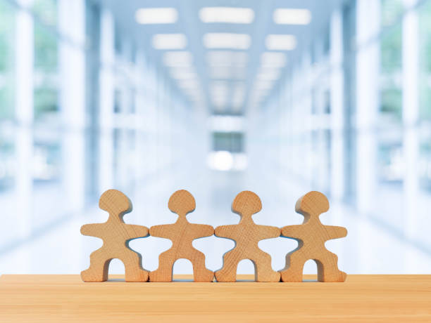 istock Teamwork and cooperation concept, wooden people team standing on table with office background 1345871451