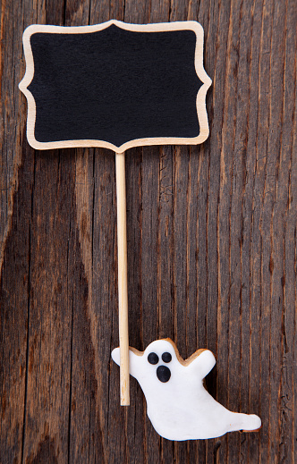 Halloween Ghost Gingerbread Cookie on Rustic Wooden Table