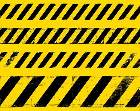 Dirty yellow and black construction barrier signage