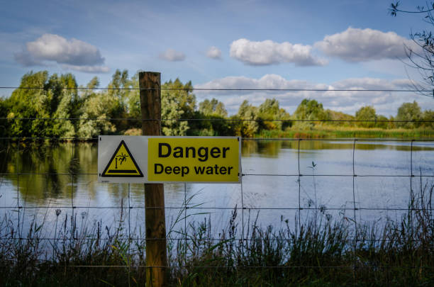 Deep water warning sign next to a lake stock photo