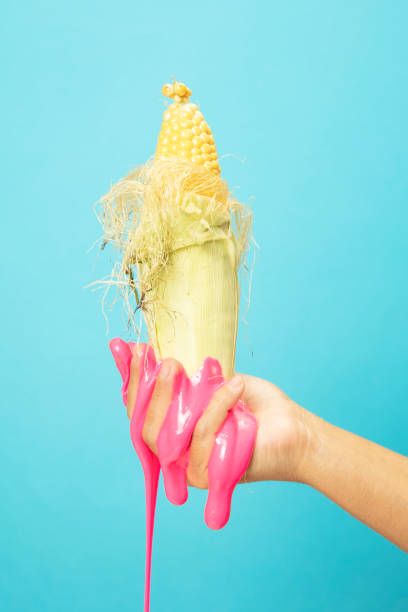 istock Hand Holding Sliced Corn cob on blue paper background. 1345878254
