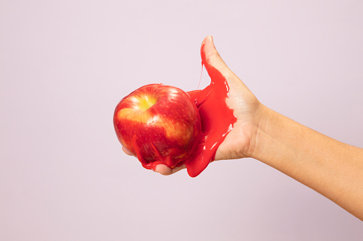 Female Hand Holding Sliced Organic PEACH  on pink pop art paper background.fruit abstract  on paper  background.