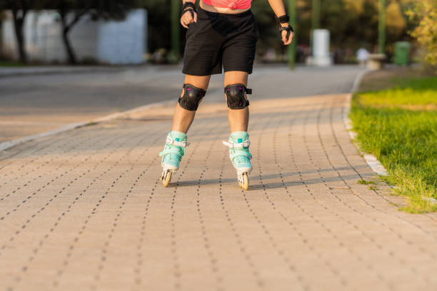 istock Person skating with inline blue skates in a path next to a park 1345880467
