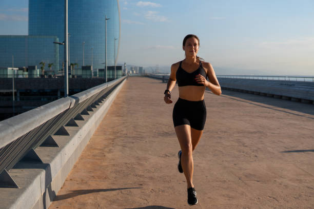 istock Determined sportswoman jogging on street 1345883130